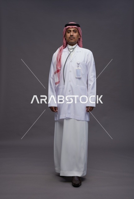طبيب عربي سعودي خليجي يرتدي الثوب والمعطف الابيض مع سماعة الطب يقوم بايماءات واشارات مختلفه, كامل الجسم, خلفيه رماديه