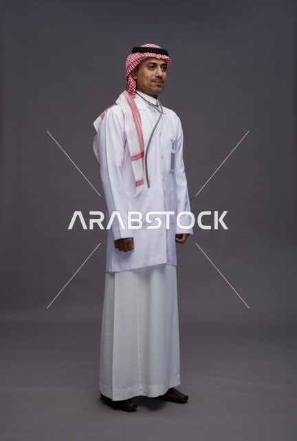 طبيب عربي سعودي خليجي يرتدي الثوب والمعطف الابيض مع سماعة الطب يقوم بايماءات واشارات مختلفه, كامل الجسم, خلفيه رماديه
