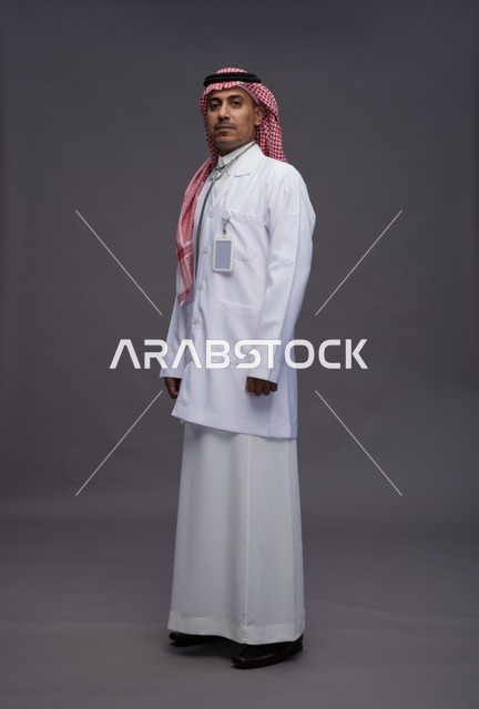 طبيب عربي سعودي خليجي يرتدي الثوب والمعطف الابيض مع سماعة الطب يقوم بايماءات واشارات مختلفه, كامل الجسم, خلفيه رماديه