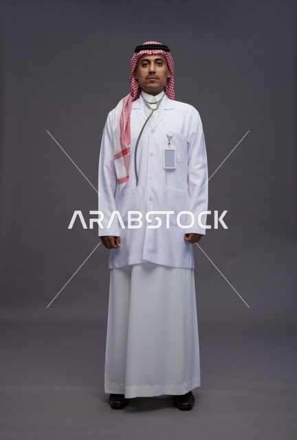 طبيب عربي سعودي خليجي يرتدي الثوب والمعطف الابيض مع سماعة الطب يقوم بايماءات واشارات مختلفه, كامل الجسم, خلفيه رماديه