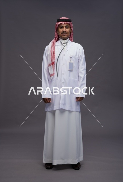 طبيب عربي سعودي خليجي يرتدي الثوب والمعطف الابيض مع سماعة الطب يقوم بايماءات واشارات مختلفه, كامل الجسم, خلفيه رماديه