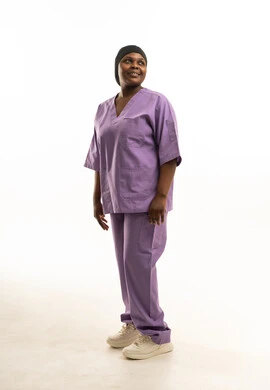 ممرضة أفريقية محجبة بزي طبي أرجواني أمام خلفية بيضاء