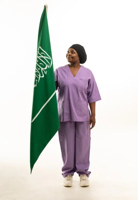 ممرضة سعودية بالزي الطبي مع العلم السعودي