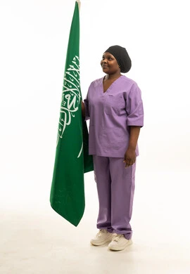 ممرضة سعودية بالزي الطبي البنفسجي مع العلم