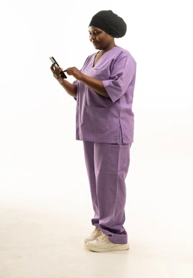 ممرضة بزي طبي أرجواني تستخدم الهاتف الذكي