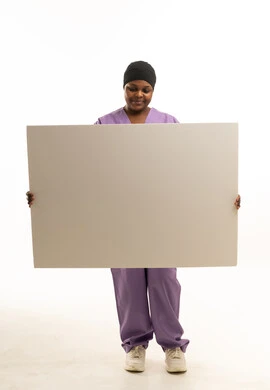 ممرضة سمراء تحمل لوحة بيضاء فارغة للإعلانات