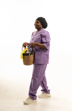 عاملة نظافة أفريقية بزي أرجواني تحمل سلة