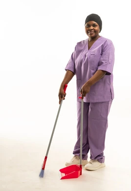 عاملة نظافة أفريقية بزي أرجواني مع مكنسة عاملة نظافة أفريقية بزي أرجواني مع مكنسة