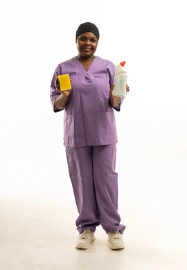 عاملة نظافة أفريقية تمسك أدوات التنظيف