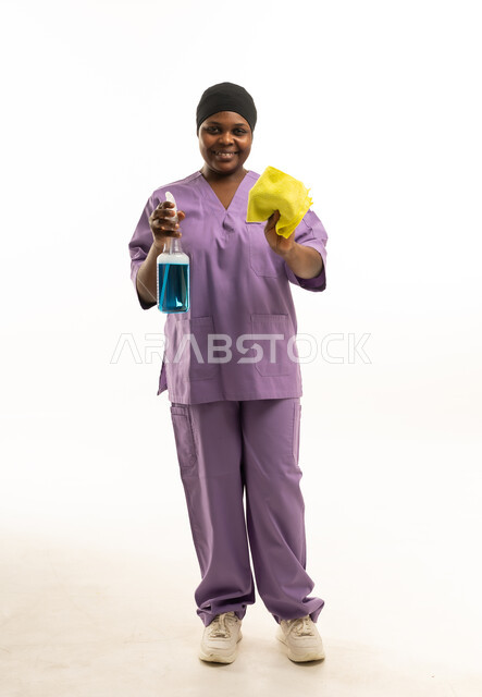 عاملة نظافة بزي أرجواني مع أدوات تعقيم
