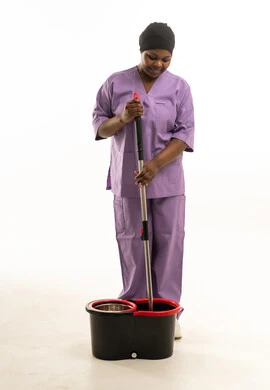 امرأة أفريقية بزي العمل تمسح الأرضية