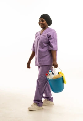 عاملة نظافة سمراء بزي أرجواني مع أدوات تنظيف