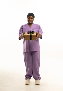 ممرضة أفريقية بالزي الأرجواني تحمل صندوق هدايا