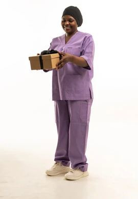 ممرضة سمراء بالزي الطبي الأرجواني تمسك صندوق هدايا