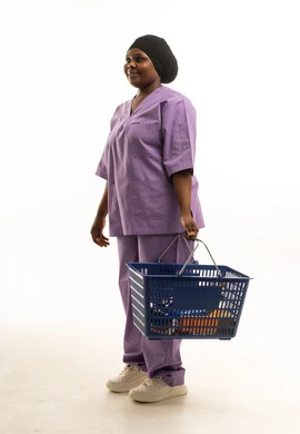 Black Nurse in Purple Scrubs Holding Shopping Basket