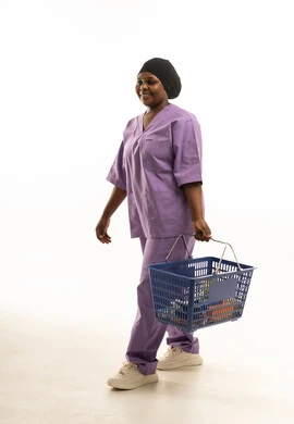 Female Nurse in Purple Scrubs Walking with Basket