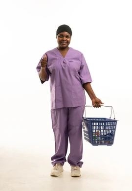 ممرضة أفريقية بالزي الطبي البنفسجي تحمل سلة تسوق