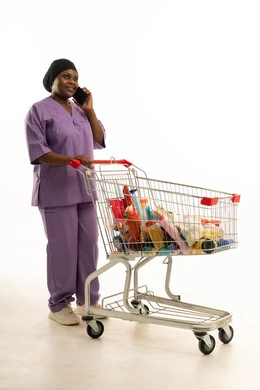 ممرضة سمراء تتحدث بالهاتف مع عربة تسوق