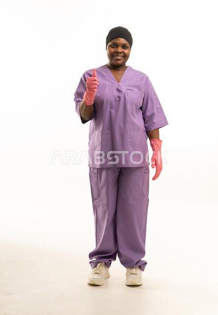 Female Nurse in Purple Scrubs with Thumbs Up Gesture - Photo