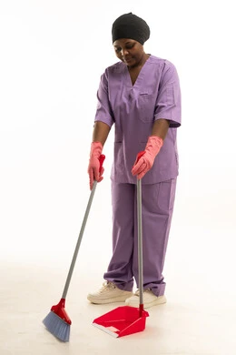 عاملة نظافة سمراء مع مكنسة ومجرود يدوي