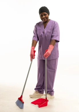 عاملة نظافة أفريقية بزي بنفسجي مع مكنسة