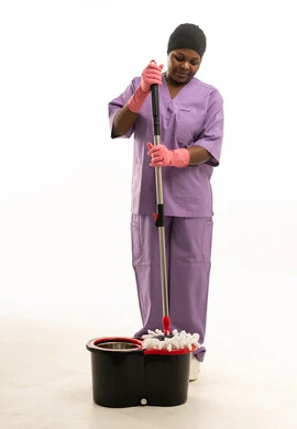 عاملة نظافة أفريقية مع ممسحة ودلو تنظيف عاملة نظافة أفريقية مع ممسحة ودلو تنظيف