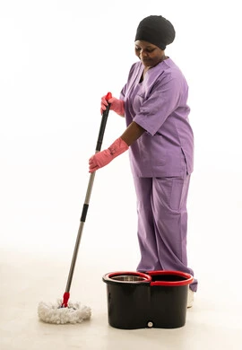 امرأة أفريقية بملابس العمل تنظف الأرض بالممسحة