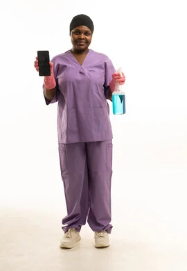 عاملة أفريقية بالزي الرسمي تحمل هاتفاً وبخاخ تنظيف عاملة أفريقية بالزي الرسمي تحمل هاتفاً وبخاخ تنظيف