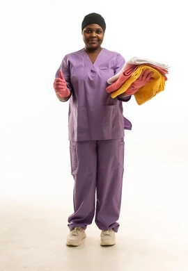 عاملة نظافة أفريقية تحمل مناشف مع إشارة إعجاب