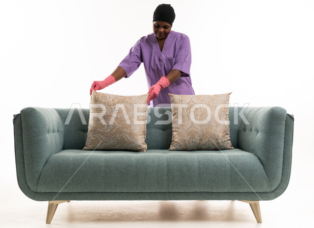 African Domestic Worker Arranging Sofa Pillows