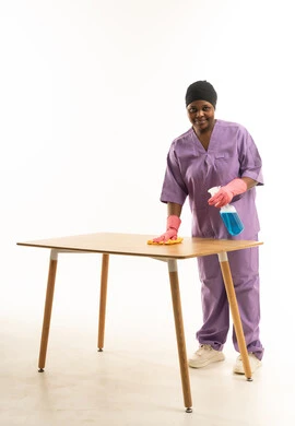 عاملة نظافة تعقم طاولة في الاستوديو