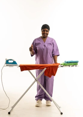 عاملة منزلية أفريقية تقوم بالكي مع إيماءة الإعجاب