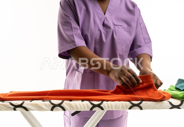 امرأة بزي أرجواني تطوي الغسيل في الاستوديو