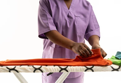 امرأة بزي أرجواني تطوي الغسيل في الاستوديو