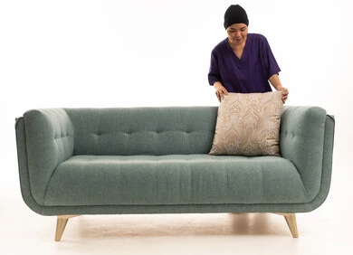 Southeast Asian Housekeeper Arranging Pillow on Sofa