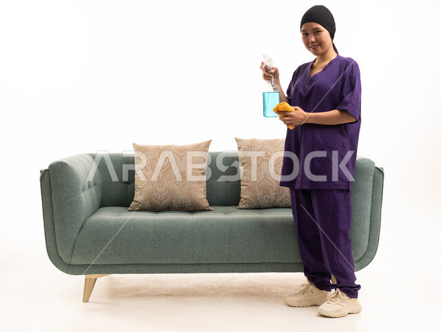 عاملة منزلية تنظف أريكة خضراء خلفية بيضاء