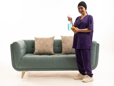 Domestic Worker Cleaning Green Sofa on White Background