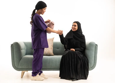 امرأة سعودية وعاملة منزلية على الأريكة امرأة سعودية وعاملة منزلية على الأريكة