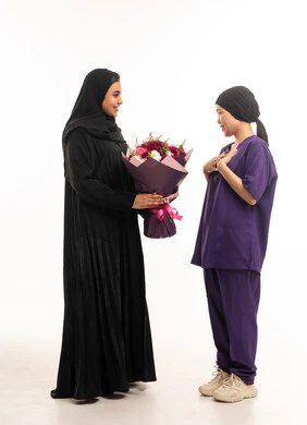 امرأة سعودية تهدي زهور لعاملة منزلية في الاستوديو