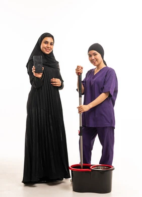 سيدة سعودية وعاملة منزلية مع هاتف ذكي في الاستوديو