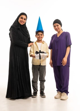 امرأة سعودية وعاملة منزلية مع طفل وهدية