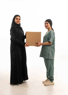 Saudi Woman and Domestic Worker with Cardboard Box