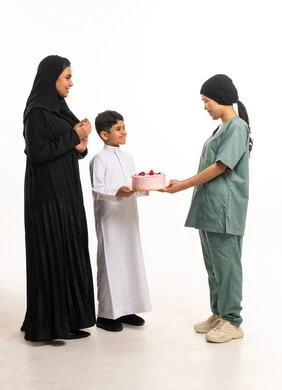 طفل وأم سعودية يقدمان كعكة لعاملة منزلية