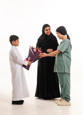 طفل سعودي يقدم ورد لعاملة منزلية خلفية بيضاء