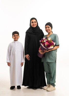 عائلة سعودية وعاملة منزلية مع باقة زهور عائلة سعودية وعاملة منزلية مع باقة زهور