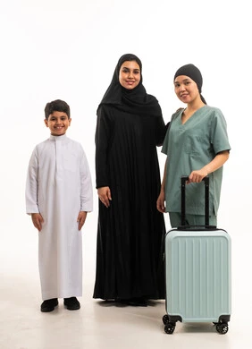 عائلة سعودية مع عاملة منزلية وحقيبة سفر في الاستوديو