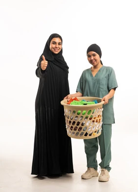 امرأة سعودية وعاملة منزلية مع سلة غسيل