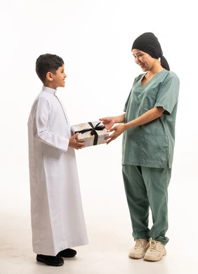طفل سعودي يقدم هدية لعاملة منزلية بخلفية بيضاء