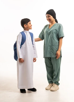 عاملة منزلية مع طالب مدرسي سعودي بخلفية بيضاء