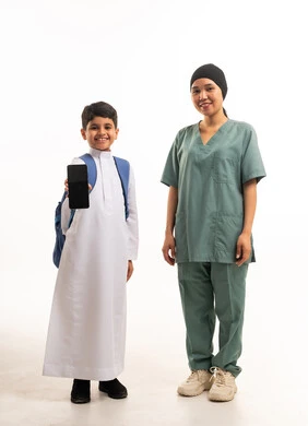 طفل سعودي وعاملة منزلية يحملان هاتف ذكي خلفية بيضاء طفل سعودي وعاملة منزلية يحملان هاتف ذكي خلفية بيضاء